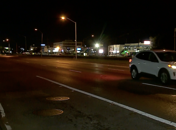 White vehicle travels on nighttime Louisiana street.