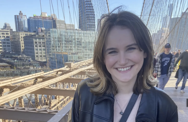 Jaclyn Elmquist smiling with view of New York City skyline in background.