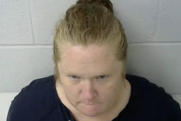 A middle aged woman wears her medium blonde hair pulled back tight during her mugshot.