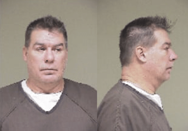 Side-by-side mugshot images show a man in a brown jail shirt, facing forward in one photo and in right-side profile in the other.