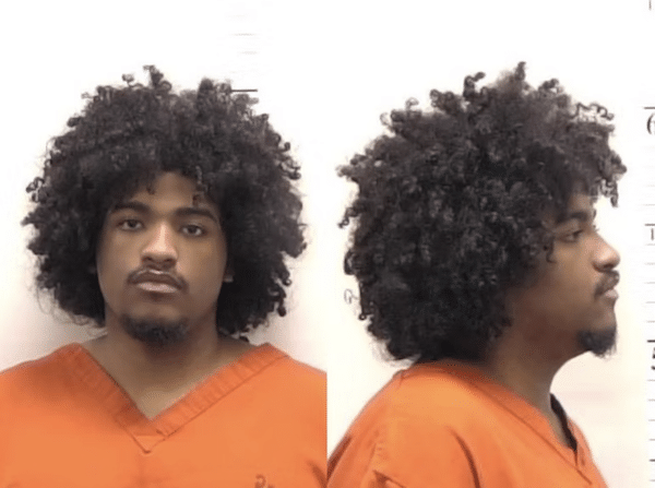 Front and side booking-style photos of a man in an orange jail uniform with thick curly hair, a mustache and a goatee against a plain light background.